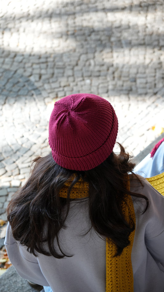 Model wearing Mozaika Collective Mulberry Burgundy Cozy Knits Beanie, warm handmade artisan hat