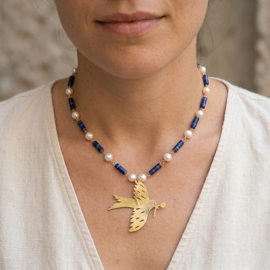 Model wearing Mozaika Collective Peace Dove Necklace, handmade brass Lapis Lazuli symbol of peace