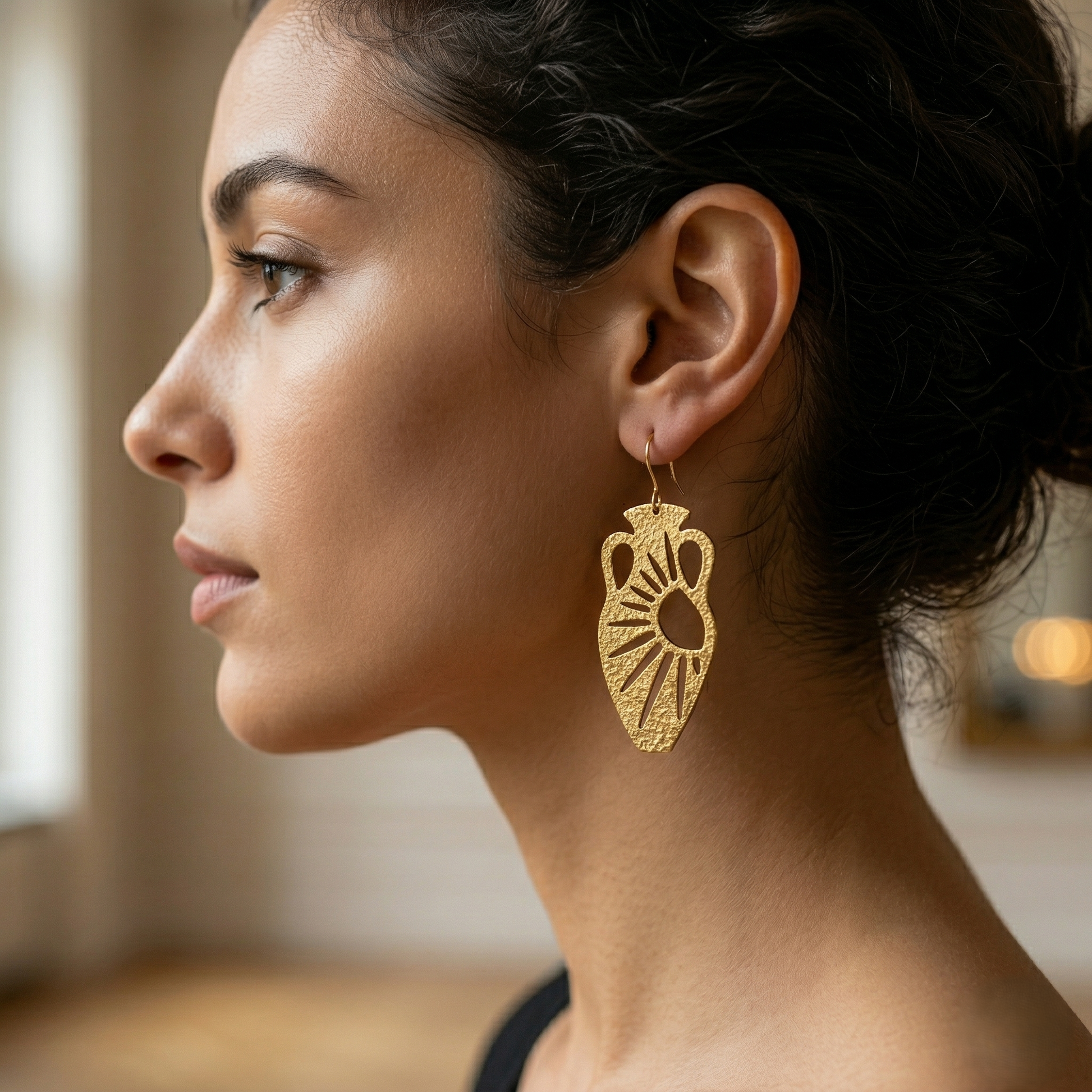 Model wearing Mozaika Collective Sun and Moon Vase Earrings, handmade solid brass statement earrings