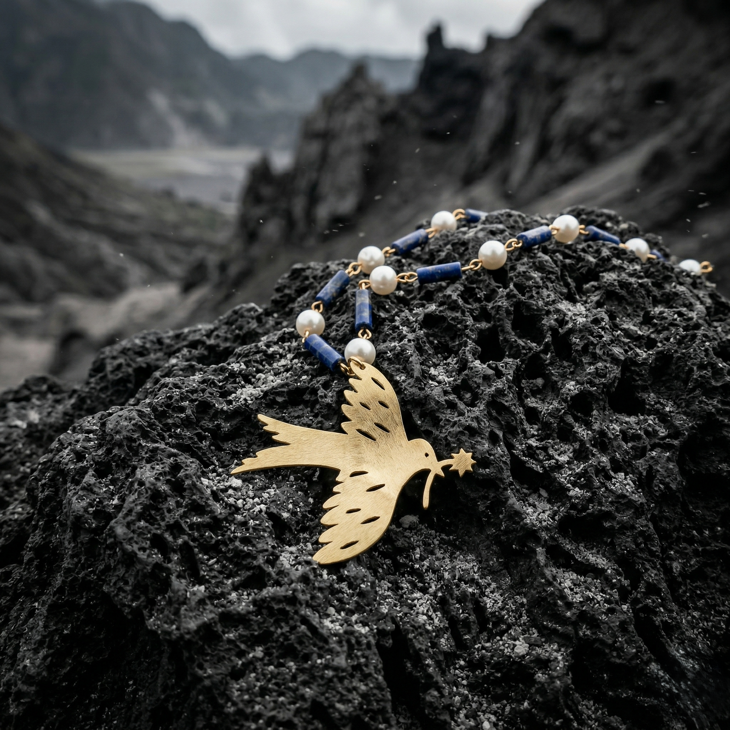 Mozaika Collective Peace Dove Necklace close-up showing brass dove with Lapis Lazuli and pearl
